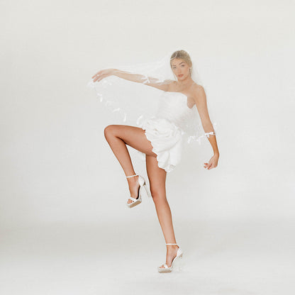 Editorial motion shot of the Brielle Mini showing playful movement and sculpted volume.