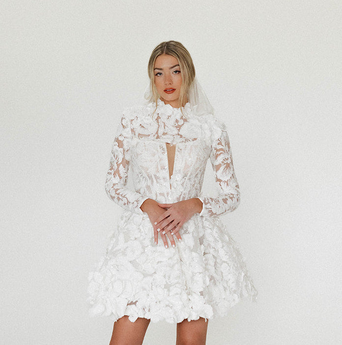 Bride wearing the Isla Bolero, a sheer sculpted 3D Couture lace detail styled with the Isla Mini in soft studio light.